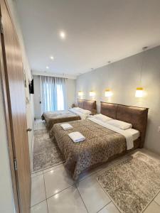 a bedroom with two beds and a door to a room at Minas Luxury Studios in Stavros