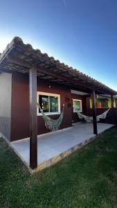 a building with a hammock outside of it at Casa Recanto de Unamar in Cabo Frio