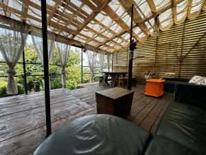 a room with a wooden deck with a pergola at ANA City Rooms in Cluj-Napoca