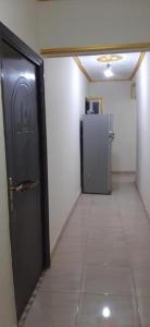 a hallway with a black door and a refrigerator at Egypt Pyramids Hotel in Cairo