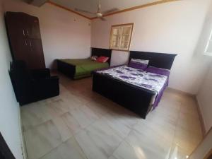 a room with two beds and a chair in it at Egypt Pyramids Hotel in Cairo +34 photos