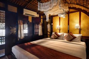 a bedroom with a large bed in a room at Spice Coast Cruises - Houseboat, A CGH Earth Experience in Alleppey