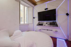 a white room with a bed and a tv at Hotel Trecento in Rome