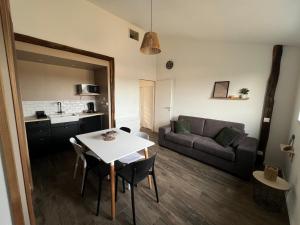 a living room with a table and a couch at Les Iris - Maison chaleureuse in Montigné-sur-Moine