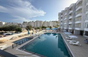 a swimming pool with chairs and umbrellas in a hotel at Hotel Eylül in Erdemli