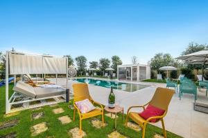 a pool with chairs and a bed and a bottle of wine at Alternative Resort & SPA in Scorrano