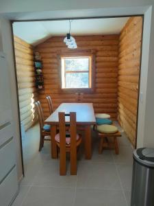 a dining room with a table and chairs in a log cabin at LOG-INN Hakuba in Hakuba