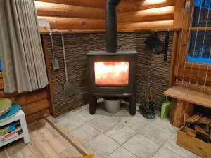 a fireplace in a room with a stove at LOG-INN Hakuba in Hakuba