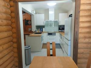 a kitchen with white appliances and a table and chairs at LOG-INN Hakuba in Hakuba