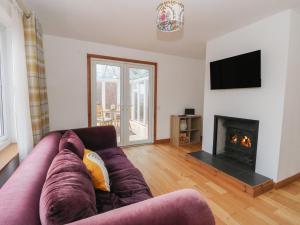 a living room with a couch and a fireplace at Doire An Daimh in Acharacle