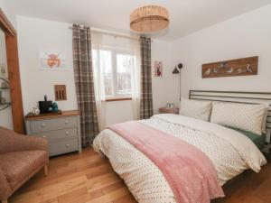 a bedroom with a bed and a chair and a window at Doire An Daimh in Acharacle