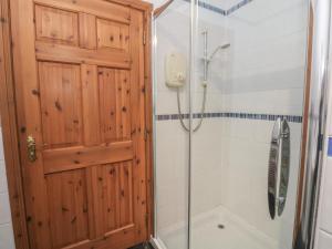 a shower with a wooden door and a shower stall at Doire An Daimh in Acharacle +29 photos