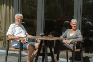 an older man and woman sitting at a table at Camping Natuurlijk Limburg - Studio 1 in Voeren +8 photos