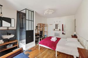 a bedroom with a large white bed and a sink at Premium 1BR flat with direct access to the RER B in Gentilly +5 photos