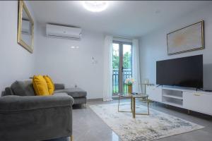 a living room with a couch and a flat screen tv at Luxury suites 2 in Kingston