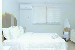 a white bedroom with a white bed and a window at Luxury suites 2 in Kingston +8 photos