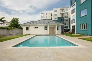 a swimming pool in front of a building at Luxury suites 2 in Kingston