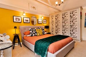 a bedroom with a bed and yellow walls at Finest Retreats - Wallis Cottage in Fishguard