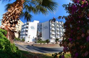 a view of a building with palm trees in the foreground at Hotel Eylül in Erdemli