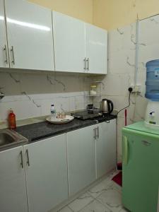 a kitchen with white cabinets and a green refrigerator at Friendlyhomes in Al Ain