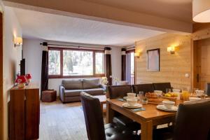 ein Wohnzimmer mit einem Tisch und einem Sofa in der Unterkunft Dormio Resort Les Portes du Mont Blanc in Vallorcine + 22 Fotos