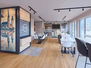 a dining room with tables and chairs and a tv at B&B HOTEL Lippstadt in Lippstadt