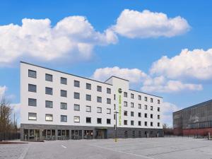 a white building with a green sign on it at B&B HOTEL Lippstadt in Lippstadt