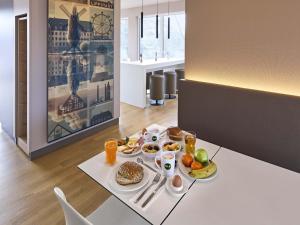 a breakfast table with food and drinks on it at B&B HOTEL Lippstadt in Lippstadt