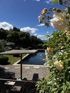 a bench and an umbrella next to a river at Le Mas de Béthel in Gordes +35 photos