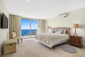 a bedroom with a bed and a view of the ocean at Casa da boa vista in Canhas