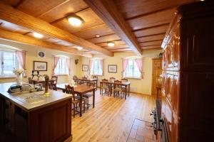 a kitchen and dining room with tables and chairs at U Bílého koníka in Kostelní Bříza