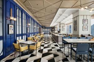 a restaurant with blue walls and tables and chairs at Le Meridien Nantong in Nantong