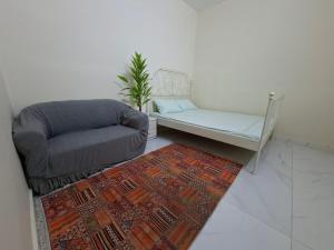 a living room with a couch and a chair and a rug at Friendlyhomes in Al Ain