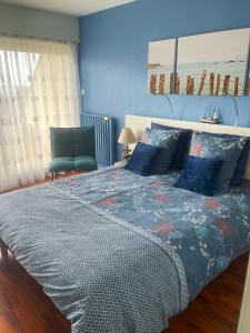 a bedroom with a large bed and a chair at Le Balcon de la Conchée in Saint Malo