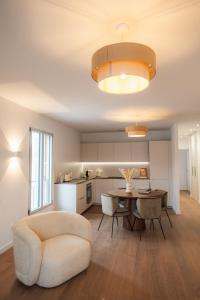 a kitchen and living room with a table and a chair at Hôtel & Suites San Roccu in Saint-Florent