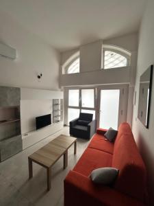 a living room with a red couch and a table at MILANO Central Station House in Milan