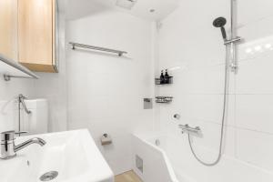 a white bathroom with a shower and a sink at Zentral und Ruhig am Park - 2BR - gratis Parken - 2 Balkone in Graz