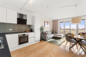 a kitchen and living room with a table and a couch at Zentral und Ruhig am Park - 2BR - gratis Parken - 2 Balkone in Graz +14 photos