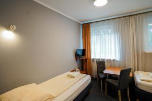 a hotel room with a bed and a desk and a window at Hotel Maraton in Kielce