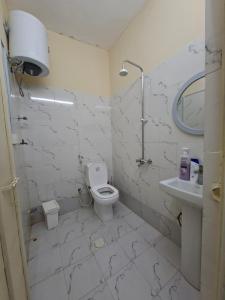 a white bathroom with a toilet and a sink at Friendlyhomes in Al Ain +2 photos