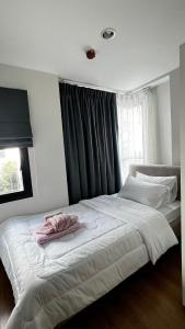 a bedroom with a large white bed with a window at Centrio 2 bed rooms 52 in Ban Lo Long