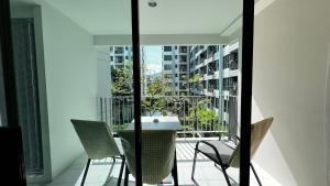 a balcony with a table and chairs on a building at Centrio 2 bed rooms 52 in Ban Lo Long
