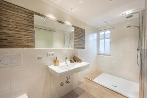 a white bathroom with a sink and a shower at Hotel Garni Carl Michael in Strobl