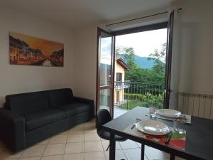 a living room with a couch and a table at Belmonte Holiday Apartment in Brezzo