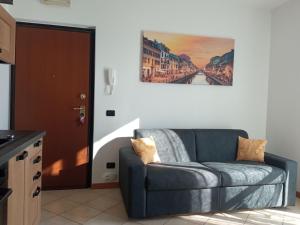 a living room with a couch and a painting on the wall at Belmonte Holiday Apartment in Brezzo