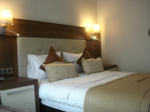 a bedroom with a large bed with white sheets and pillows at Vesta Fuar Otel in Konak