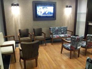 a waiting room with chairs and a tv on the wall at Vesta Fuar Otel in Konak