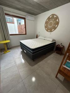 a bedroom with a bed in the corner of a room at Loft 2 quartos with full kitchen in Uruçuca