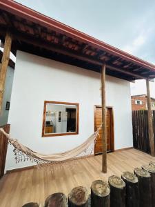 a house with a hammock on a deck at Loft 2 quartos with full kitchen in Uruçuca