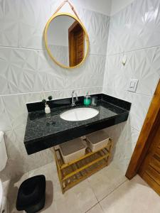 a bathroom with a sink and a mirror at Loft 2 quartos with full kitchen in Uruçuca
